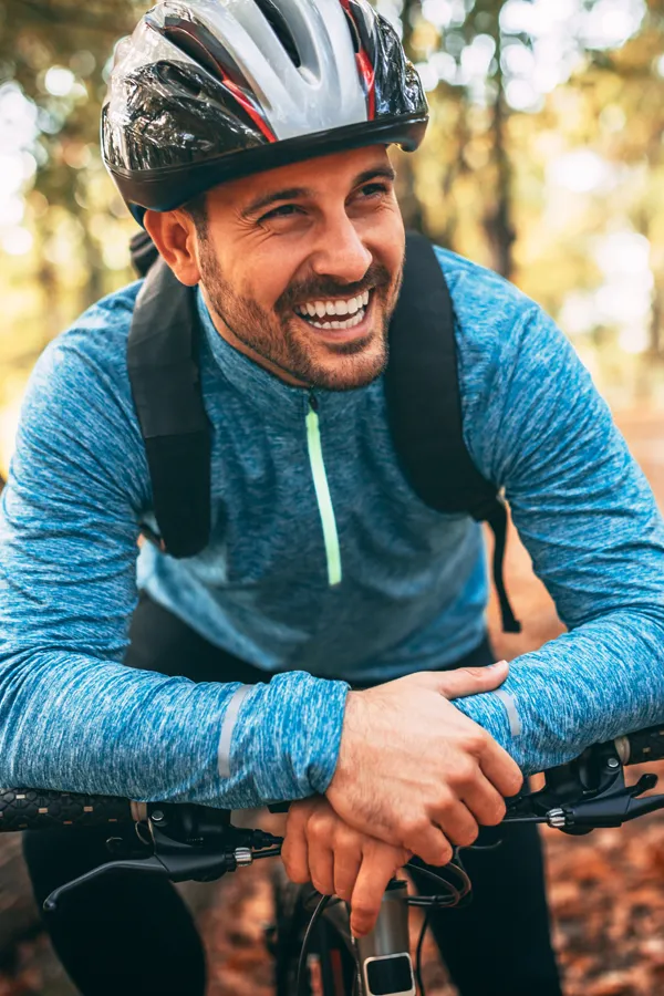 Adrenal-Hormone-Disorder-Treatment A smiling man getting ready for a cycling trip. Get treatment for adrenal hormone disorder from Kane Lai, MD in Dallas-Fort Worth Metroplex.