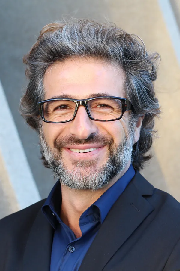 Andropause-and-Low-Testosterone-Treatment A man with glasses, salt and pepper hair and a beard smiling because he received treatment for andropause and low testosterone from Kane Lai, MD in Dallas-Fort Worth Metroplex.