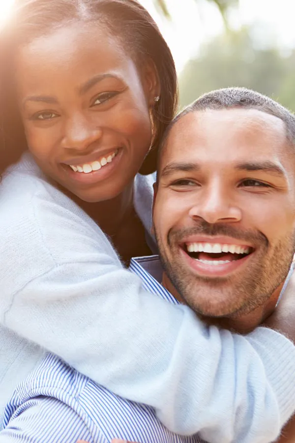Erectile-Dysfunction-Treatment A woman riding on a man's back, both smiling due to help with erectile dysfunction from Kane Lai, MD in Dallas-Fort Worth Metroplex.
