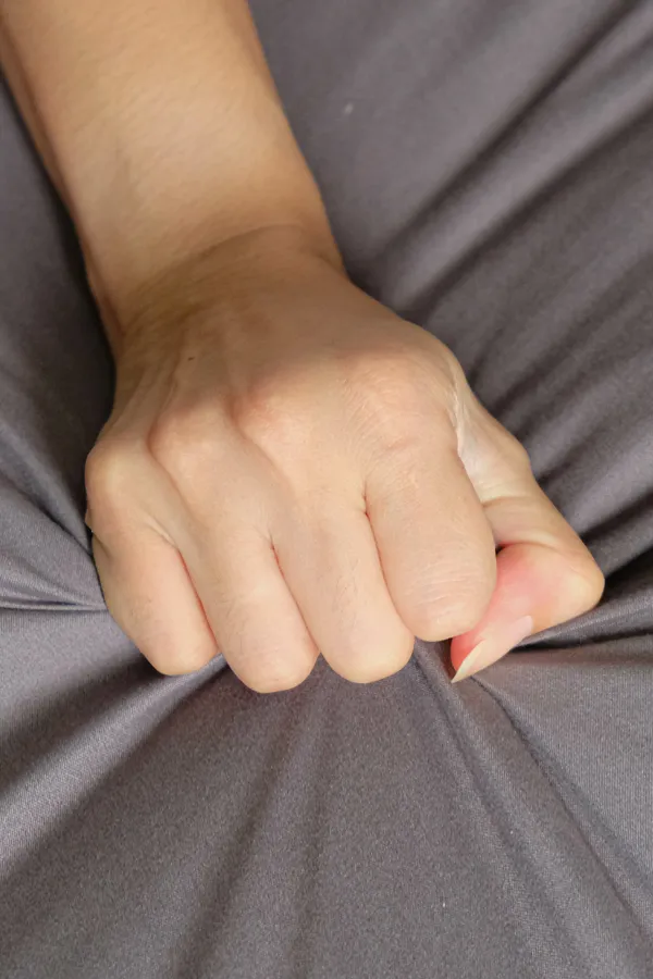 Female-Sexual-Dysfunction-Treatment Close-up of a woman's hand grabbing a sheet, indicating sexual pleasure. Get female sexual dysfunction treatment from Kane Lai, MD in Dallas-Fort Worth Metroplex.