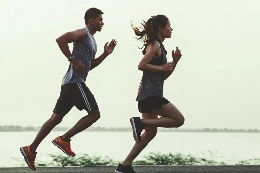 GLP-1-Weight-Loss-Injections-Clinic A couple in profile running along the water. Schedule GLP-1 Weight Loss Injections from Kane Lai, MD in Dallas.