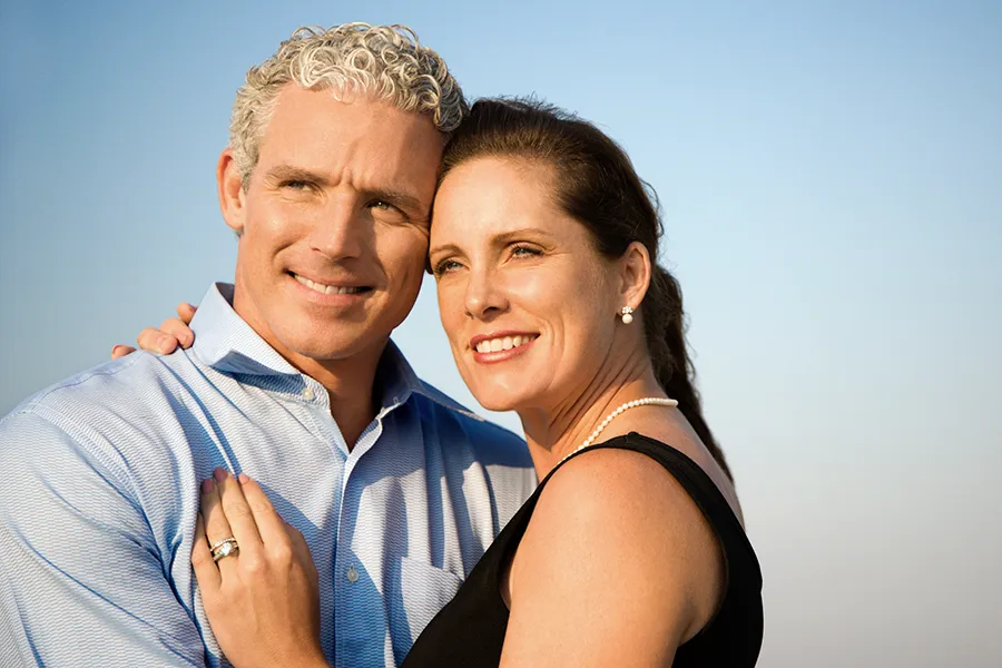 Healthy-Aging-Peptides-Doctor A middle-aged caucasian couple embraces in the sunshine, happy with the healthy aging peptide treatments from Kane Lai, MD in Dallas-Fort Worth Metroplex