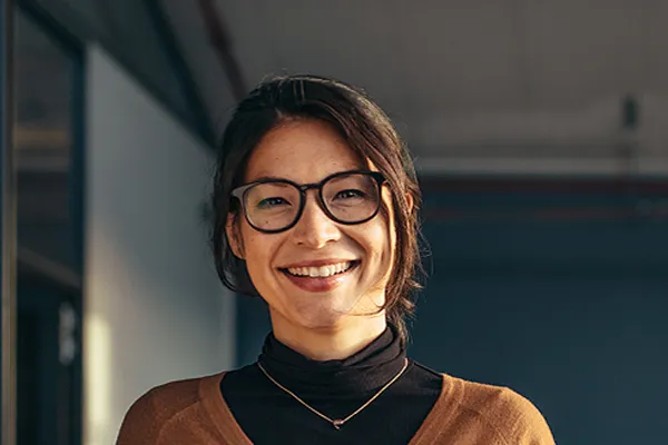Metabolic-Syndrome-Clinic A brunette woman with glasses smiles in a gray-blue walled office. Get metabolic syndrome from Kane Lai, MD in Dallas-Fort Worth Metroplex.