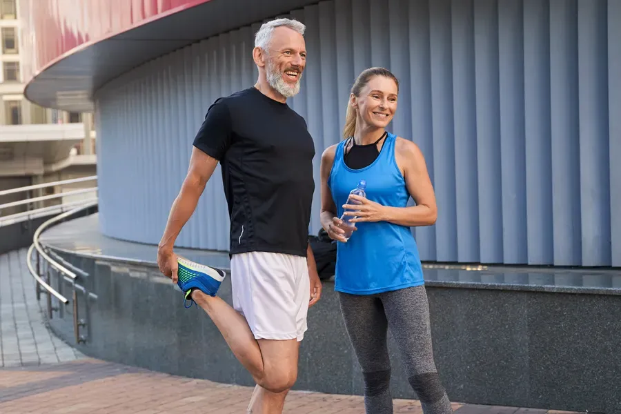 Peptides-for-Healing-and-Recovery-Doctor A middle-aged couple happily stretch and prepare for exercise after receiving effective peptide therapy for healing and recovery from Kane Lai, MD in Dallas-Fort Worth Metroplex.