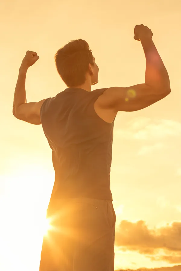 Physician-Guided-Weight-Loss-Treatment A man flexes his arms in the sunrise. Get a consultation about physician-guided weight loss programs from Kane Lai, MD in Dallas-Fort Worth Metroplex.