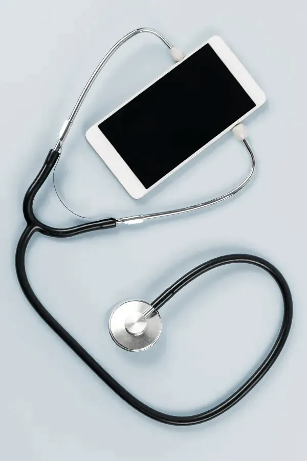 Telemedicine-Treatment A smartphone with a stethoscope attached to it, symbolizing Telemedicine treatment from Kane Lai, MD in Dallas.