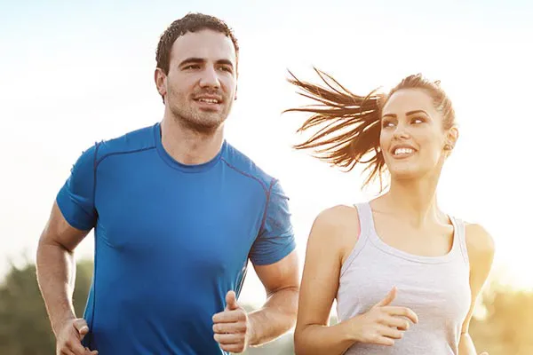Weight-Loss-Resistance-Doctor A couple happily jogging in the sunlight after receiving effective weight loss resistance care from Kane Lai, MD in Dallas-Fort Worth Metroplex.